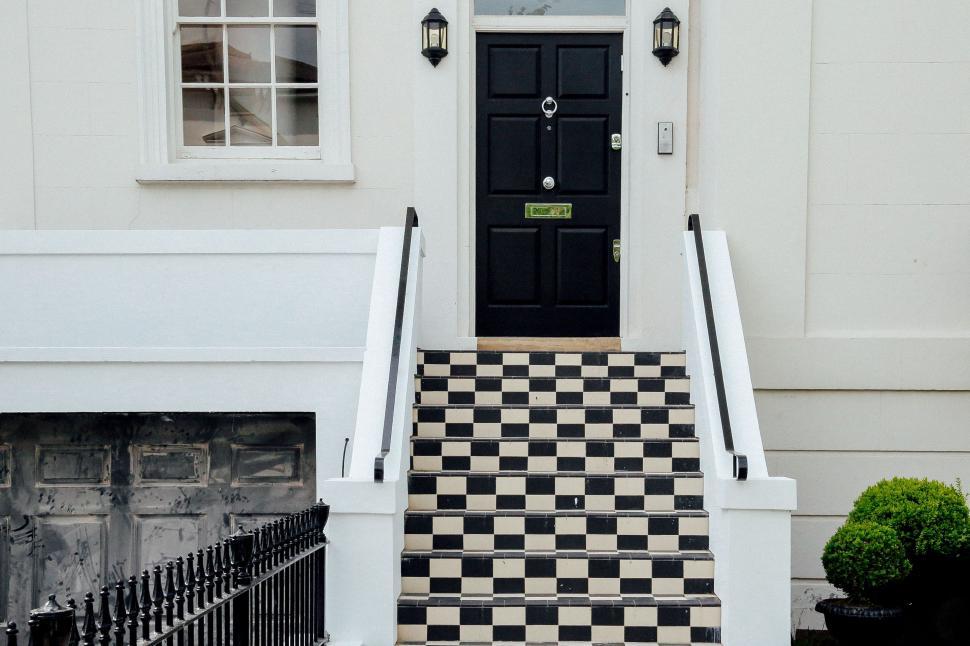 Free Image of Black and White Checkerboard Staircase Leading to Black Door 