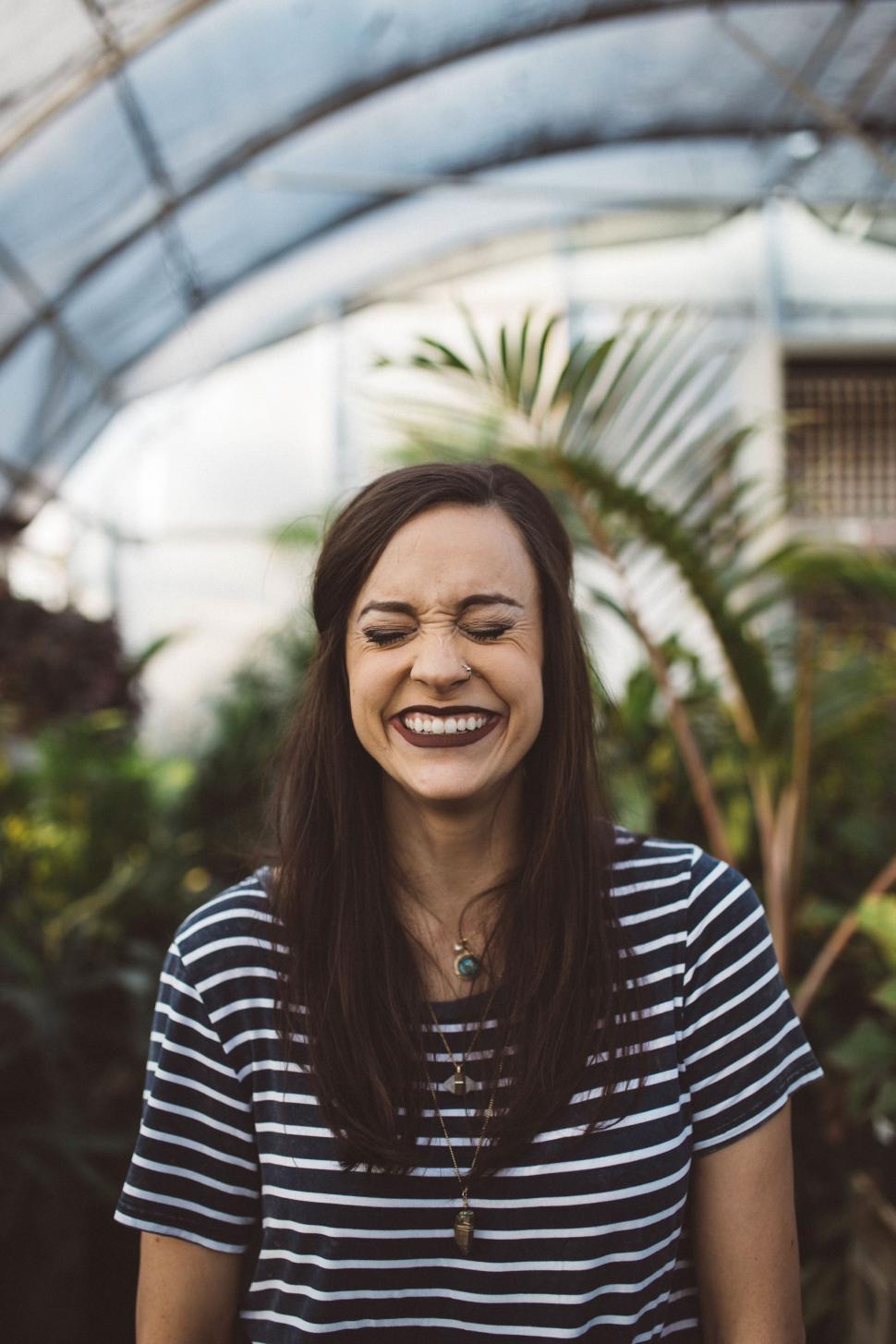Free Image of Smiling Woman With Long Hair in Greenhouse 