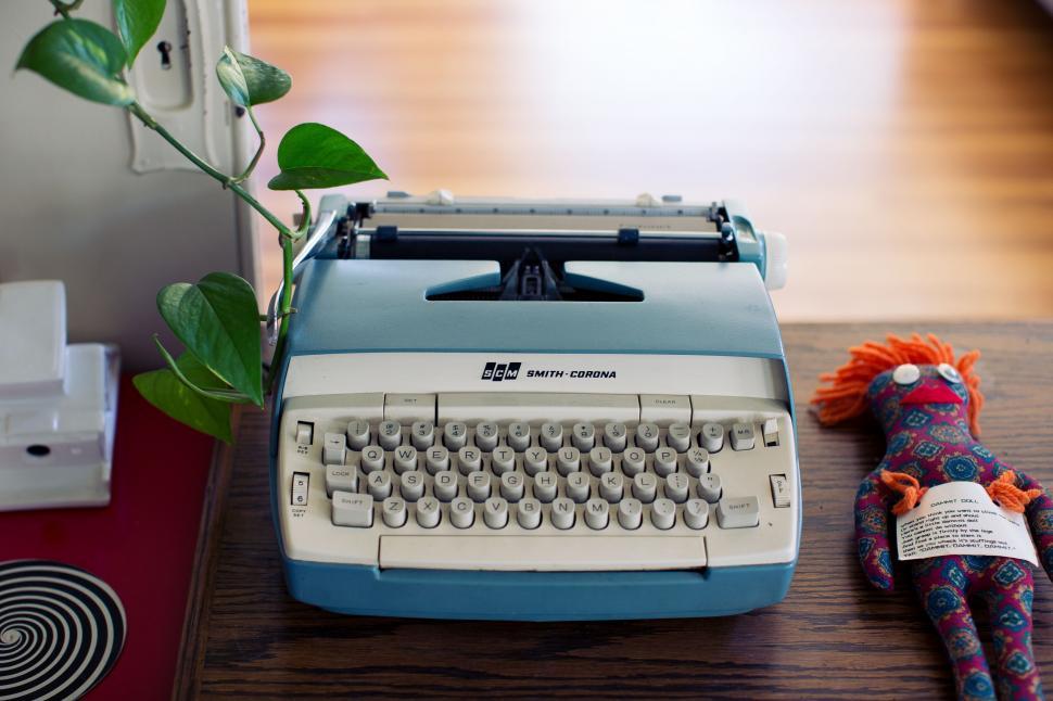 Free Image of Stuffed Animal Beside Typewriter on Table 