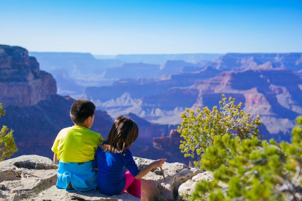 Free Image of Kids Sitting on Top of a Cliff 