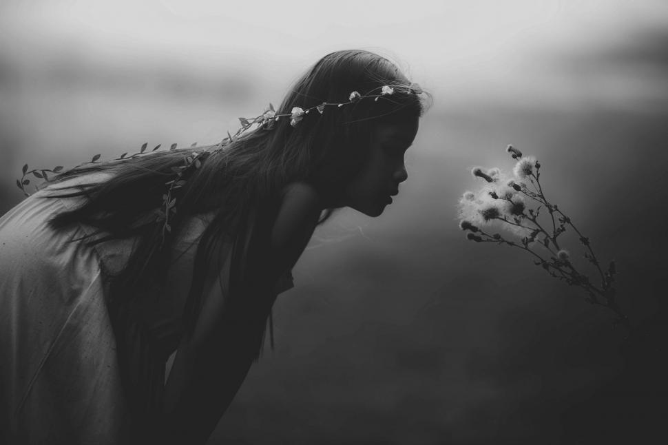 Free Image of Woman Smelling Flower in Black and White 