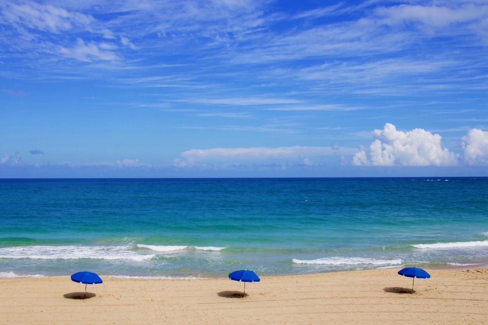 Free Image of Sandy Beach With Blue Umbrellas 