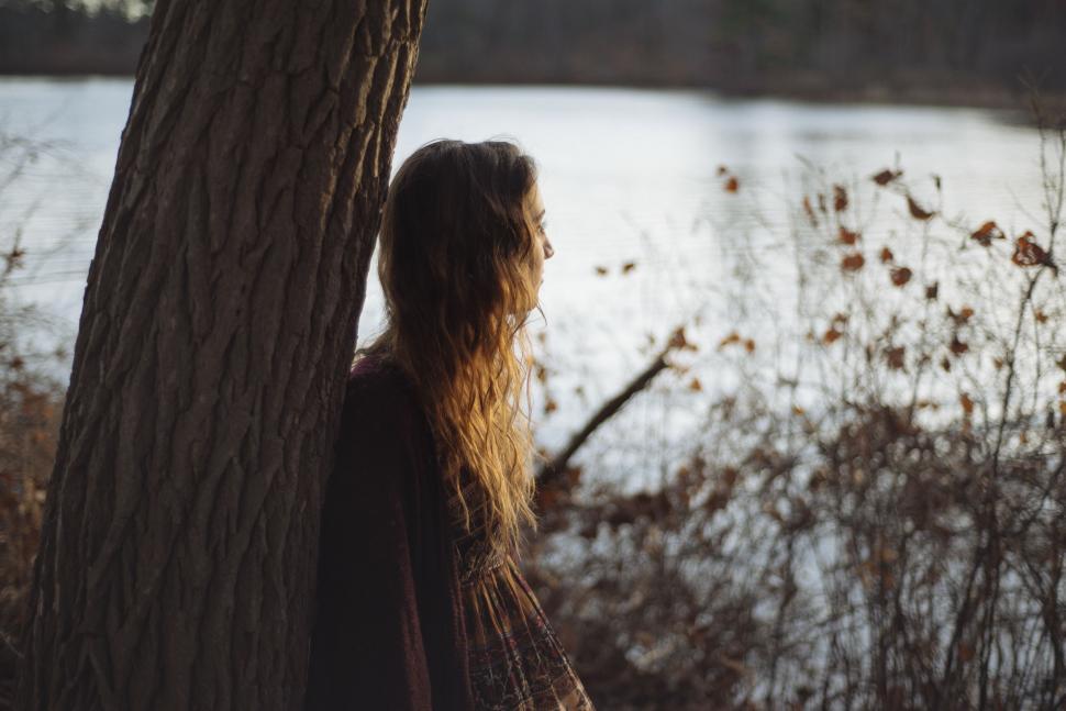 Free Image of Woman Standing Next to Tree by Water 