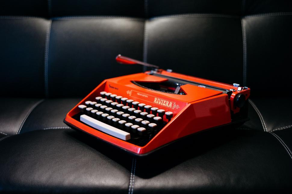 Free Image of Red Typewriter on Black Leather Couch 