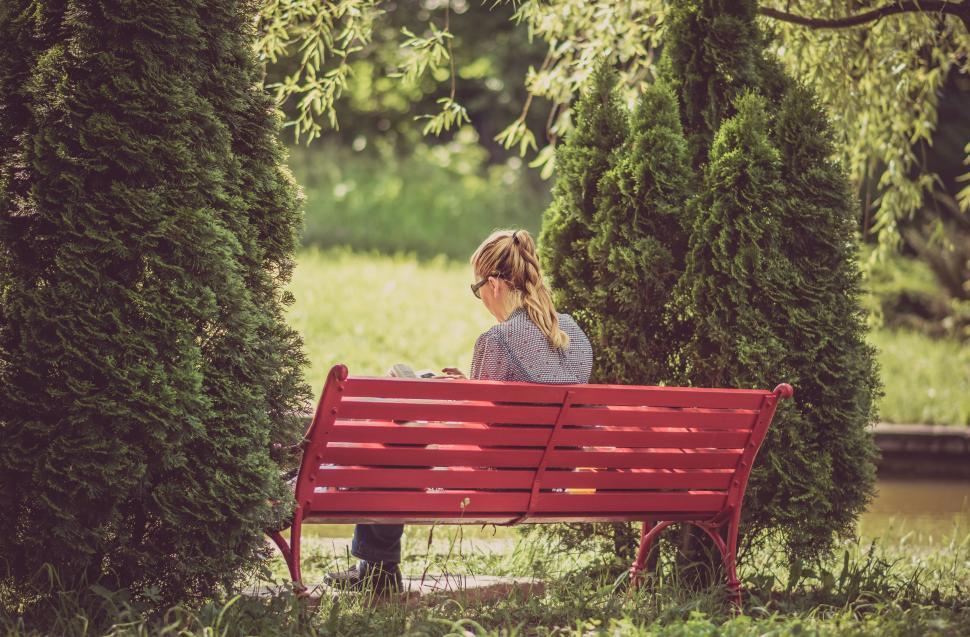 Free Image of Woman Sitting on Red Bench in Park 