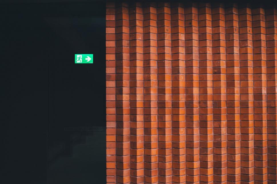 Free Image of Red Brick Wall With Green Sign 