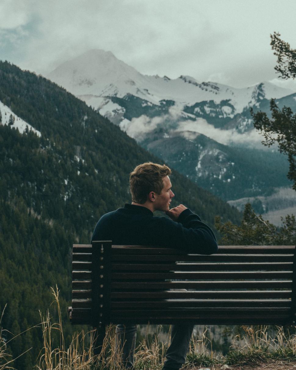 Free Image of Man Sitting on Bench in the Mountains 