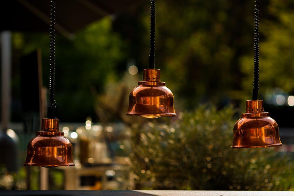 Free Image of Three Copper Colored Lights Hanging From a Ceiling 