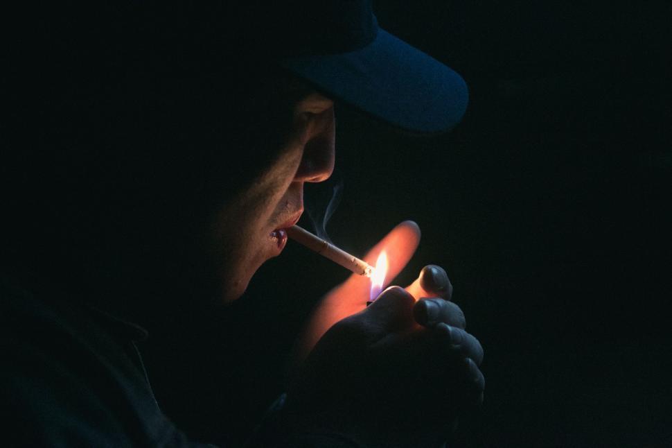 Free Image of Man Lighting a Cigarette in the Dark 