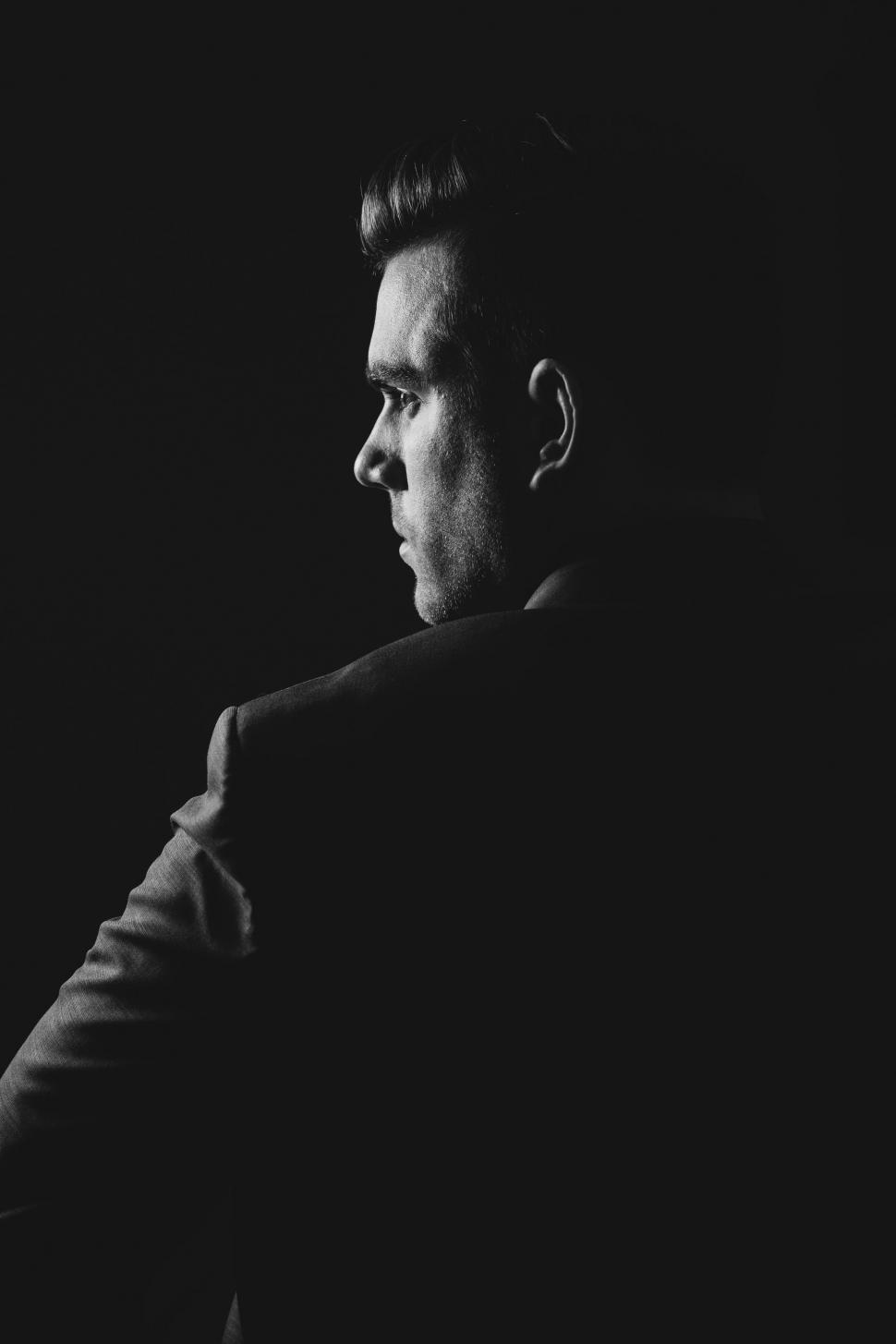 Free Image of A Man in a Suit Standing in Black and White 
