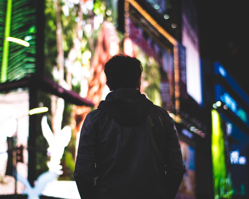 Free Image of A Man Walking Down a Street at Night 