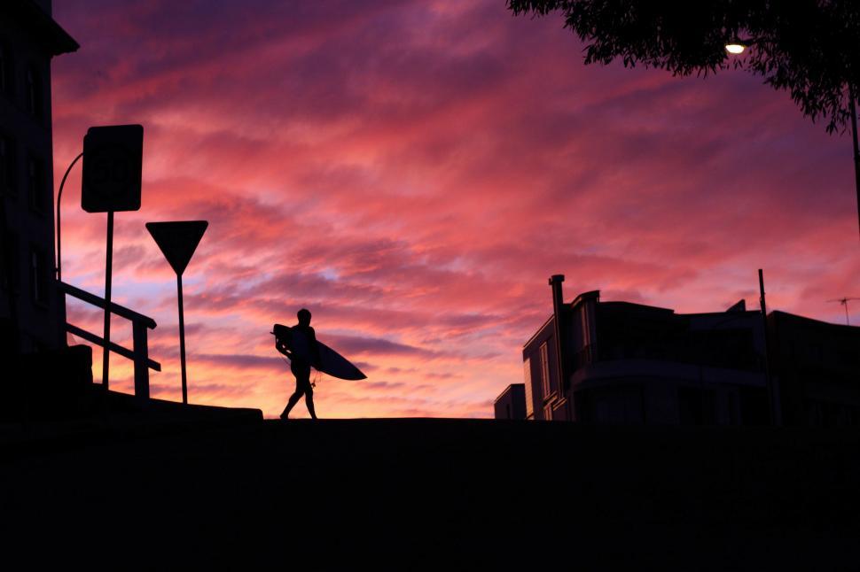 Free Image of Silhouette of Person Holding Surfboard 