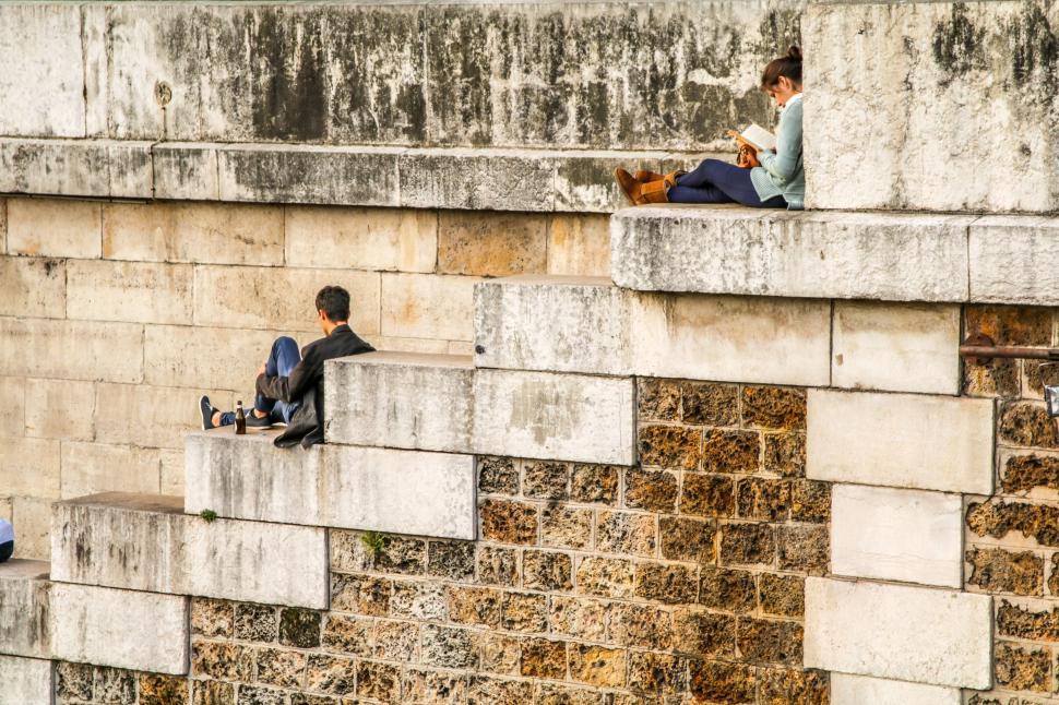 Free Image of Couple Sitting on Brick Wall 