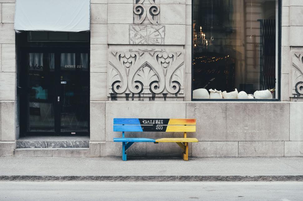 Free Image of Yellow and Blue Bench in Front of Building 