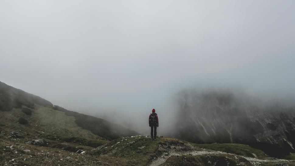 Free Image of Person Standing on Top of a Mountain in the Fog 