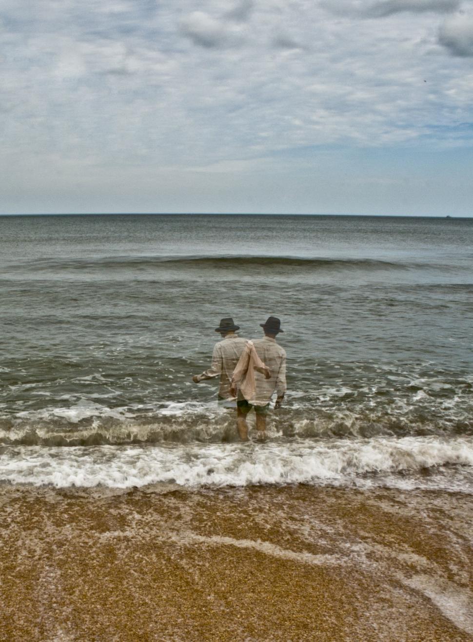 Free Image of Two Men Standing on Sandy Beach 
