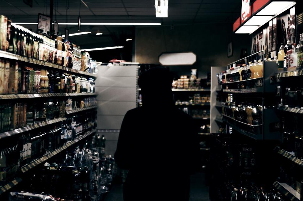 Free Image of Person Walking Through a Store Filled With Bottles 