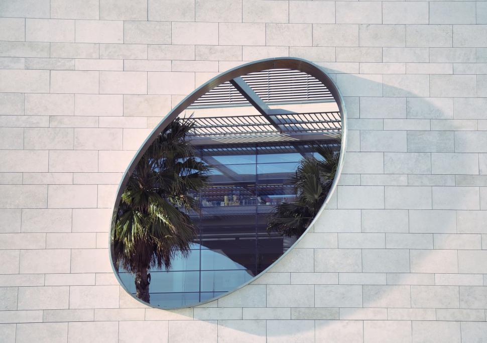 Free Image of Round Mirror Affixed to Building Facade 