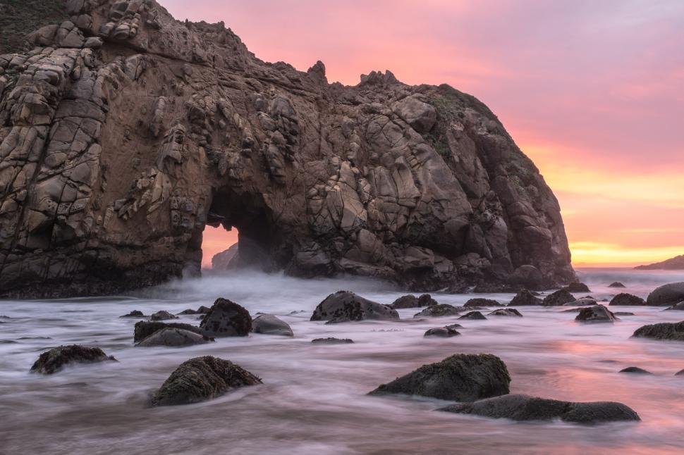 Free Image of Massive Rock Formation on Beach by Ocean 