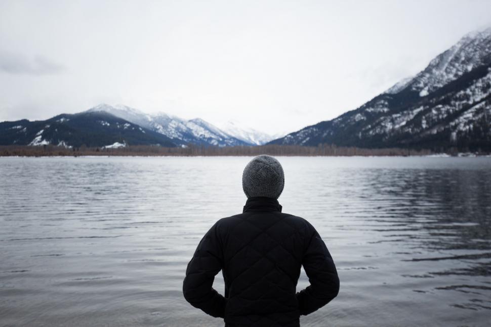 Free Image of Person Standing in Water With Mountains in Background 