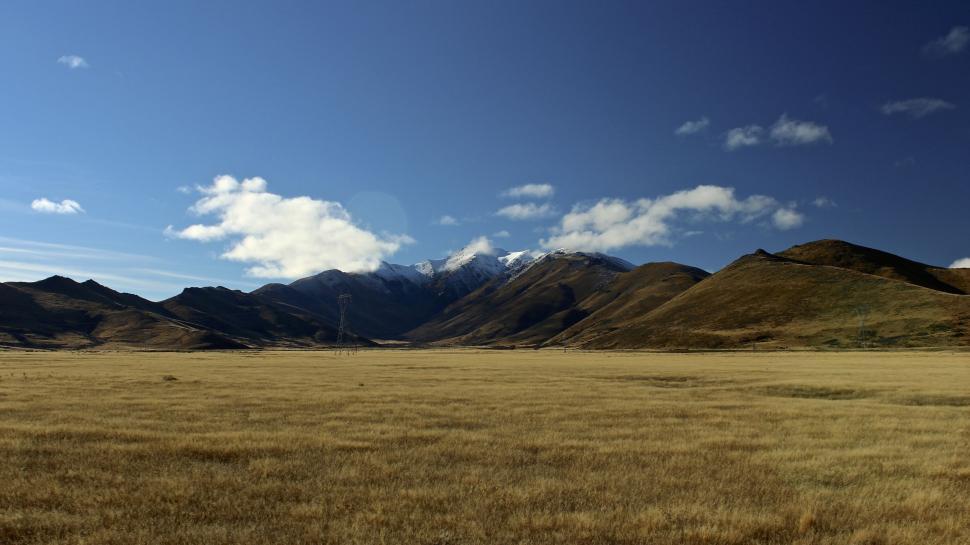 Free Image of Wide Open Field With Mountains in Background 
