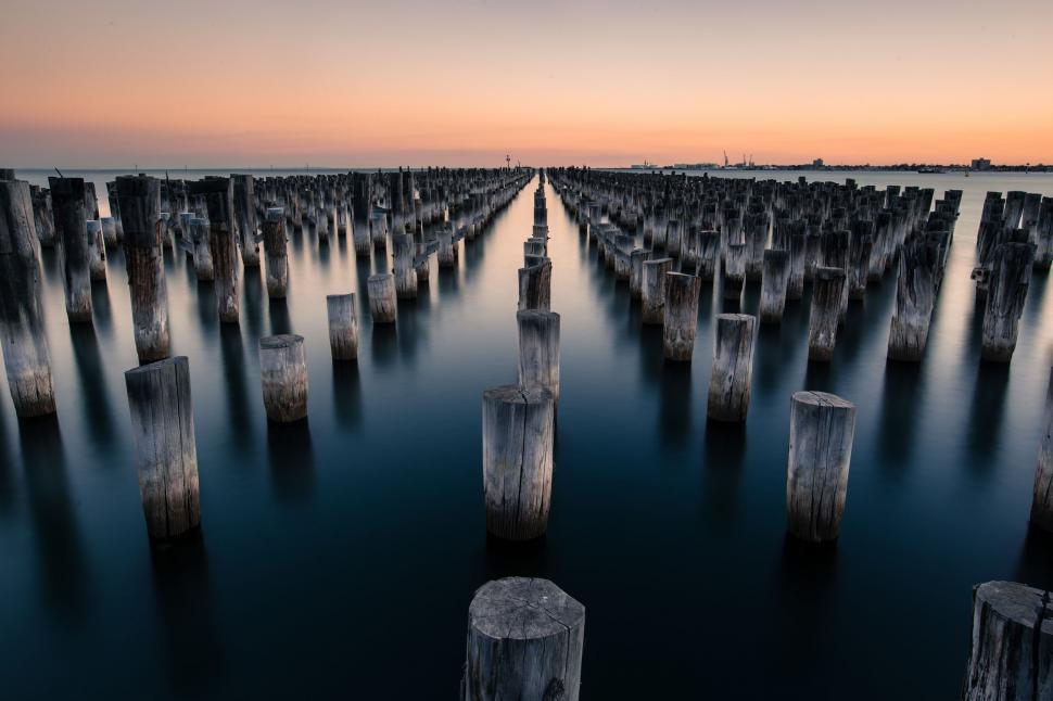 Free Image of Large Body of Water Surrounded by Wooden Posts 