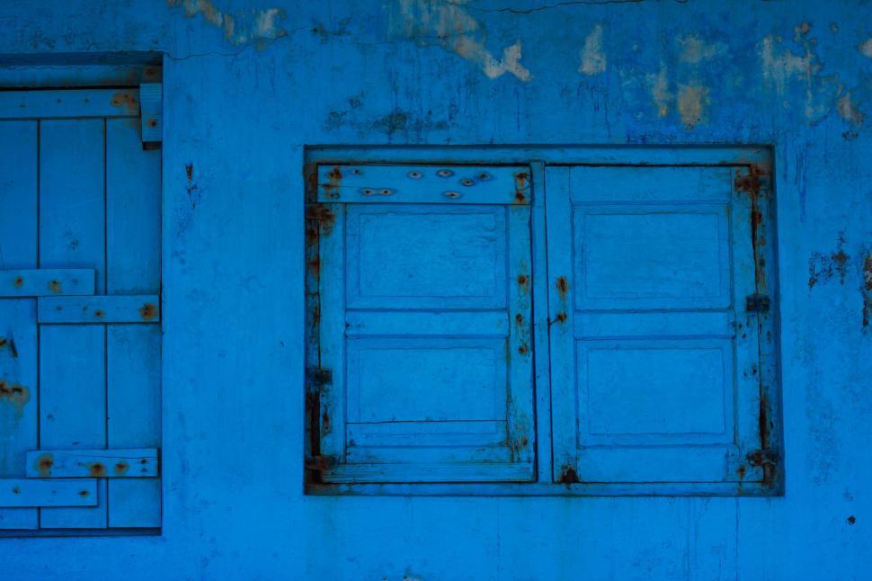 Free Image of Blue Wall With Two Windows and a Bench 