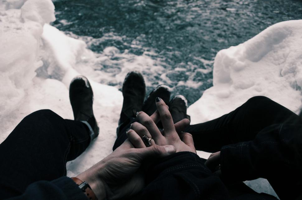 Free Image of Two People Holding Hands by the River 