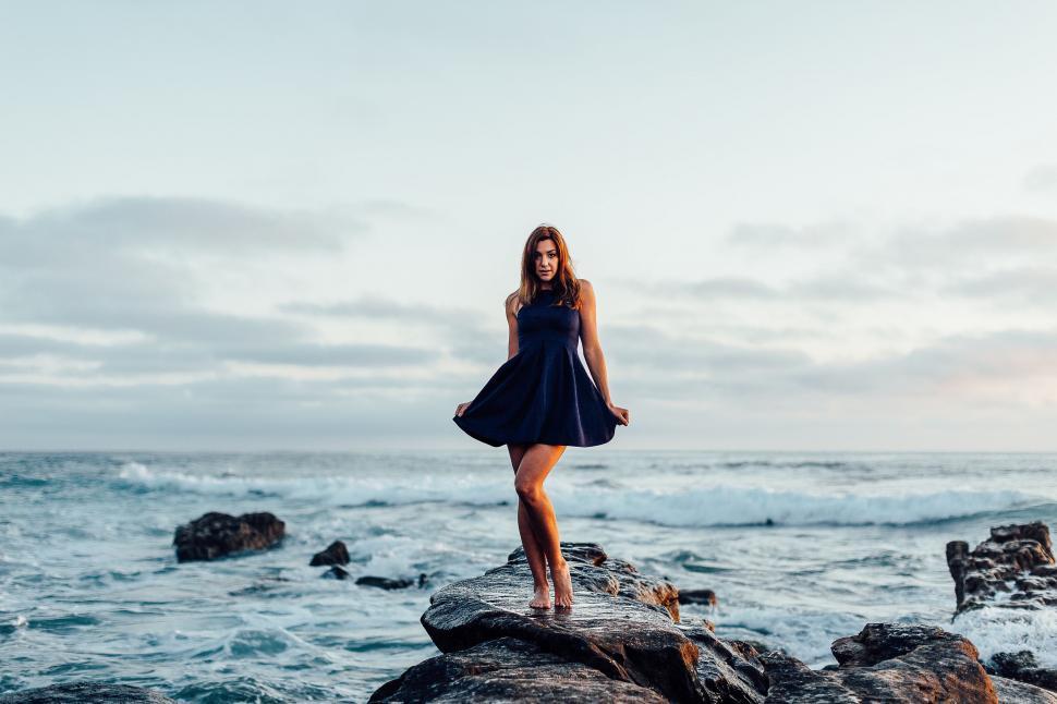 Free Image of Woman Standing on Rock Near Ocean 