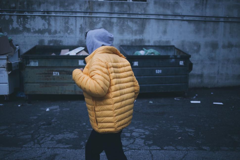 Free Image of Person in Yellow Jacket Walking Down Street 