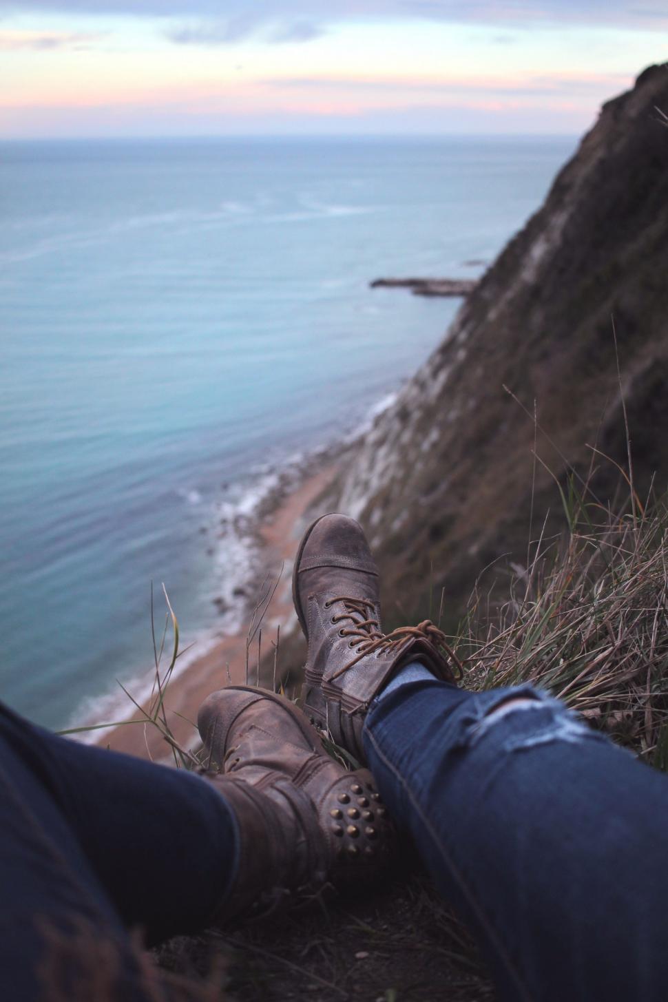 Free Image of Feet Resting on Cliff Overlooking Ocean 