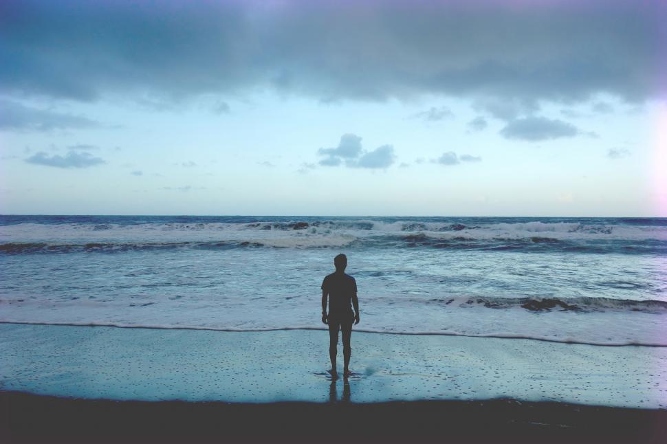 Free Image of Person Standing on Beach Next to Ocean 