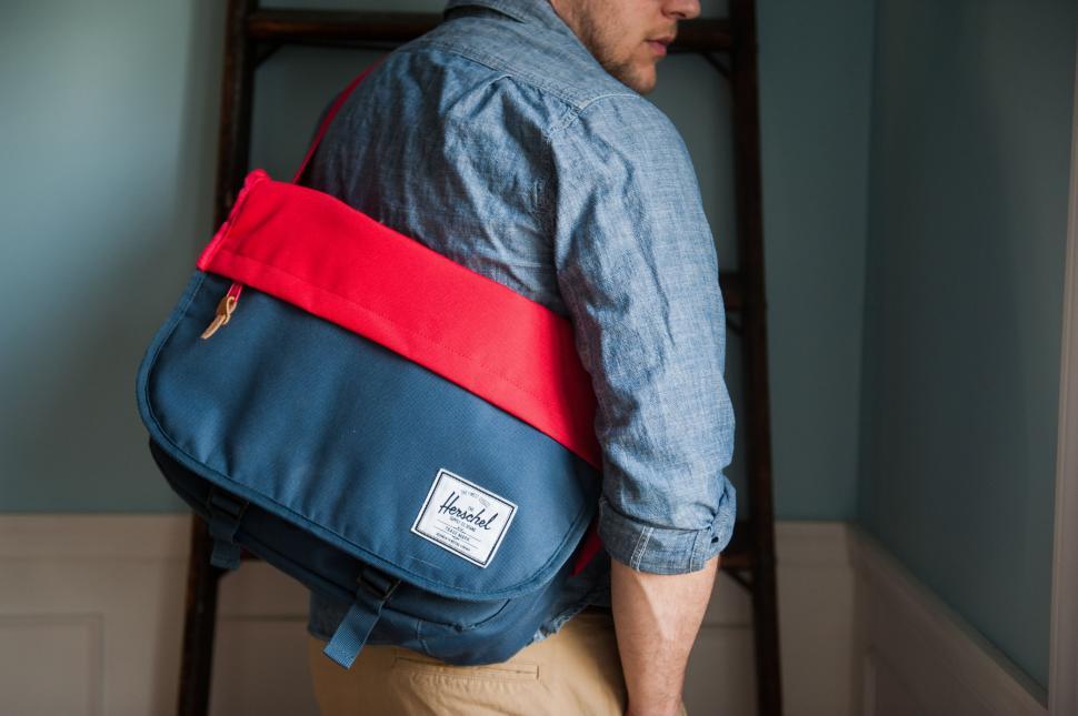 Free Image of Man Carrying Blue and Red Bag on His Back 