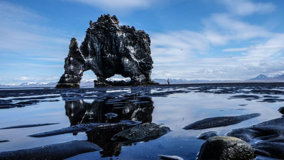 Free Image of Rock Formation Rising From Body of Water 