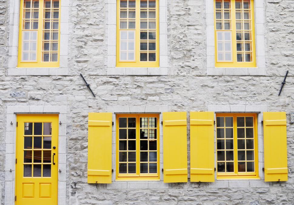 Free Image of Stone Building With Yellow Windows and Shutters 