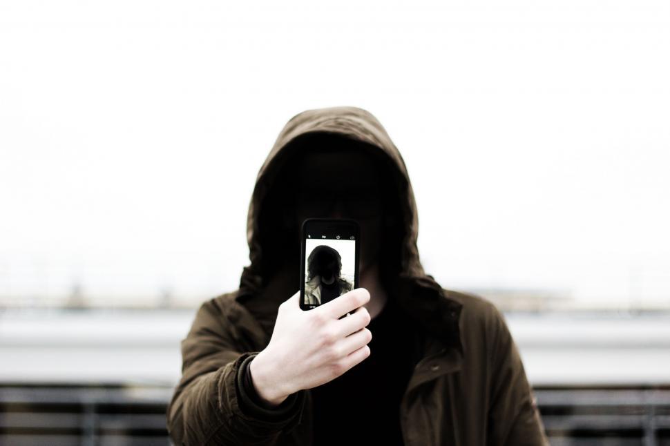Free Image of Person in Hoodie Taking Picture With Cell Phone 