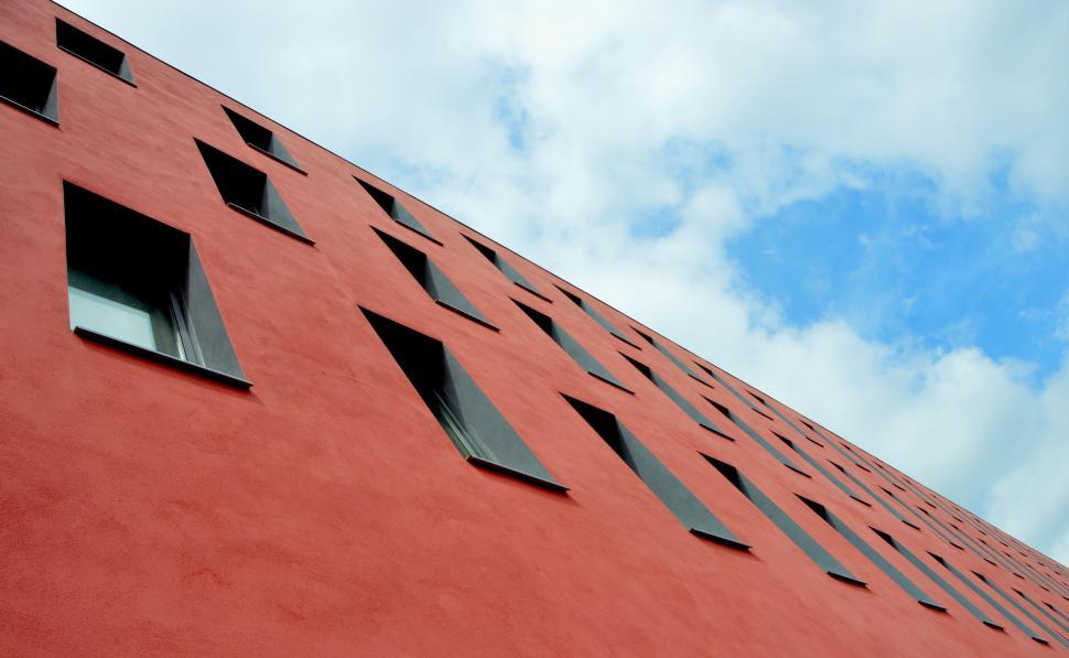 Free Image of Red Building With Windows Against Sky Background 