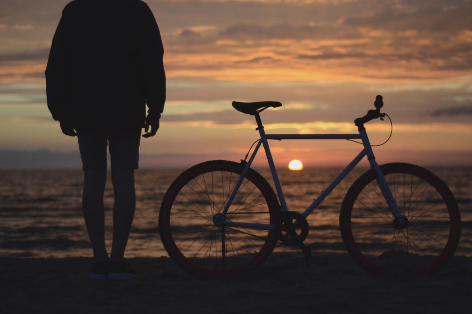 Free Image of Person Standing Next to Bike on Beach 