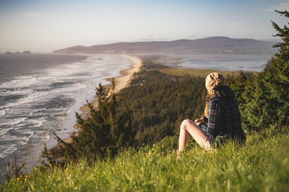 Free Image of Person Sitting on Hill Overlooking Ocean 
