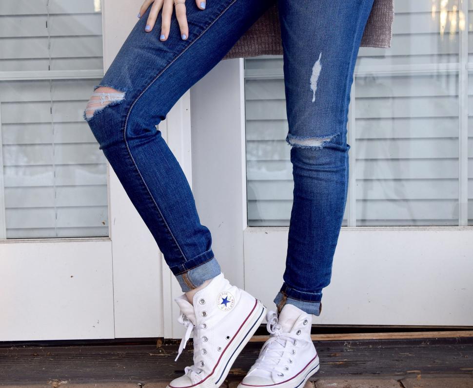 Free Image of Woman in Ripped Jeans and White Sneakers 