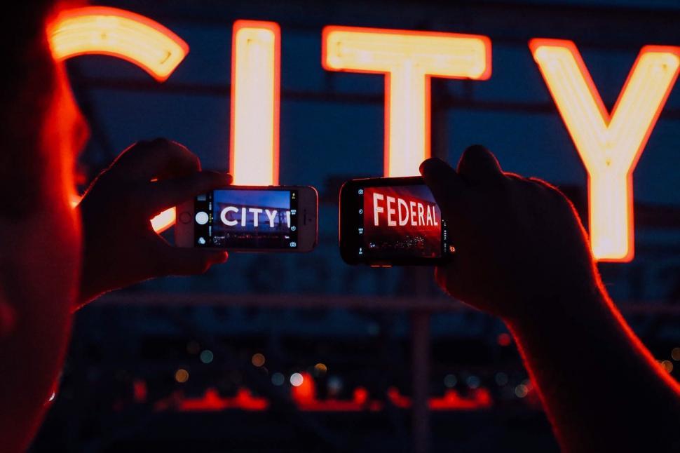 Free Image of Tourists Taking Pictures of City Sign 
