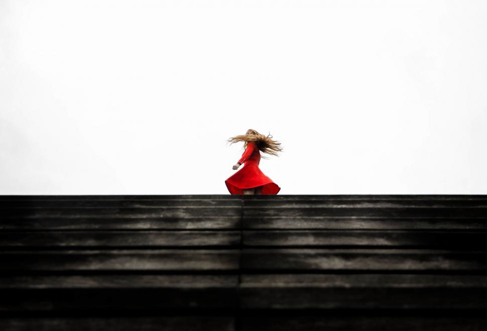 Free Image of Woman in Red Dress Walking Down Stairs 