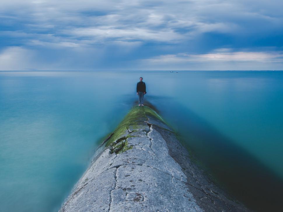 Free Image of Individual Standing on Edge of Pier in Ocean 