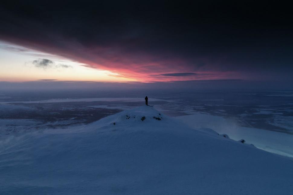 Free Image of Person Standing on Top of Snow Covered Mountain 