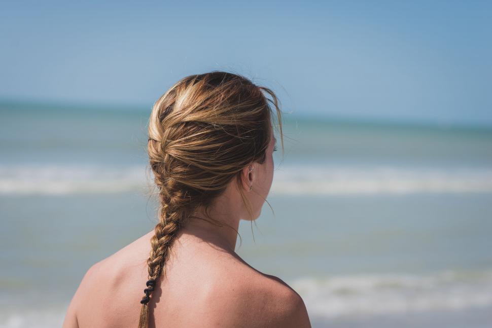 Free Image of Woman Standing on Beach Looking at Ocean 