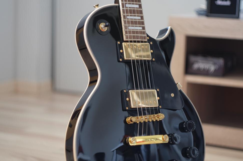 Free Image of Black Guitar on Wooden Floor 