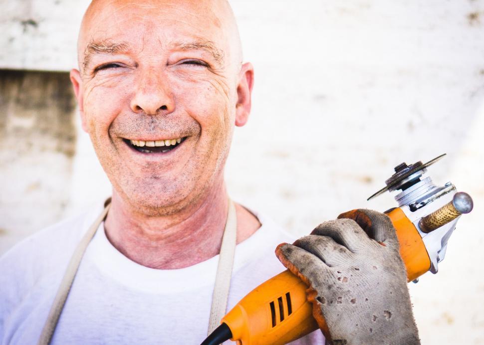 Free Image of Smiling Man Holding Drill and Hammer 