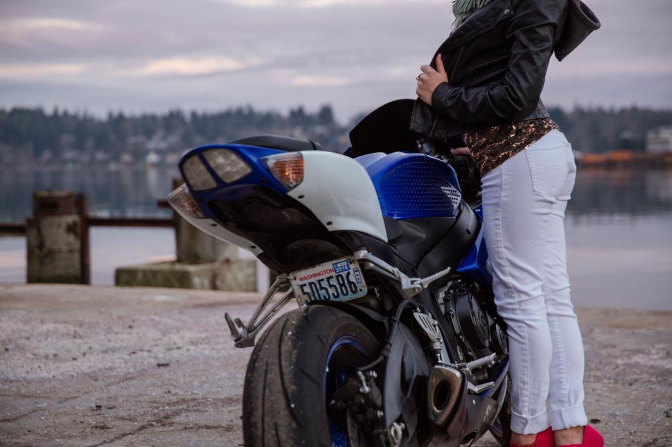 Free Image of Woman Standing Next to Parked Motorcycle 