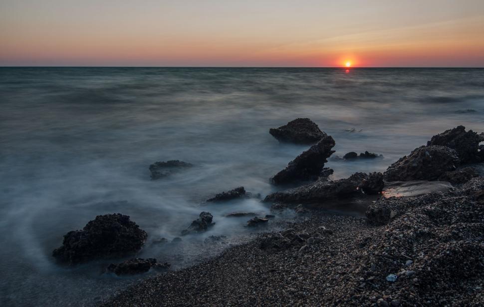 Free Image of Sun Setting Over Ocean With Rocks 