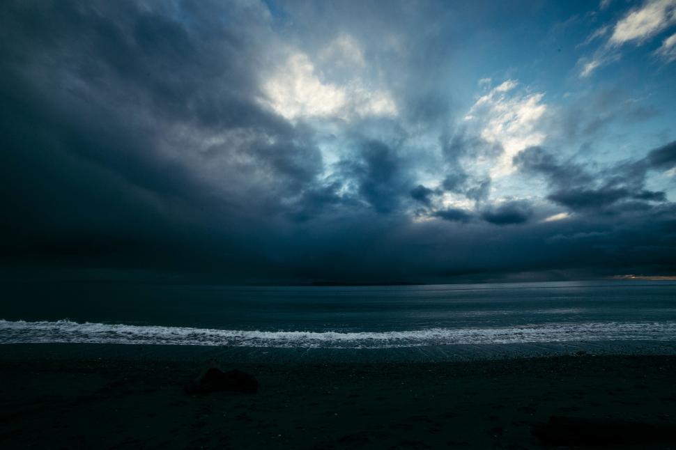 Free Image of Cloudy Sky Over Ocean With Waves Coming In 